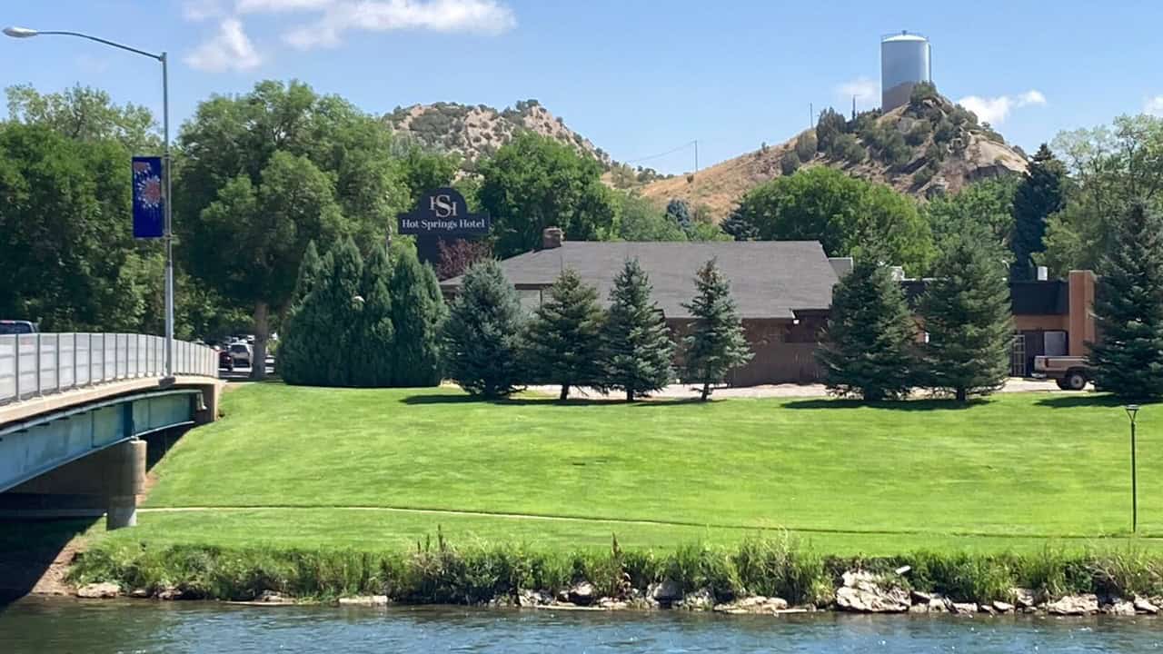 Scenic view of Oasis Motel & RV Park with lush green lawn and trees in Meeteetse, Wyoming.