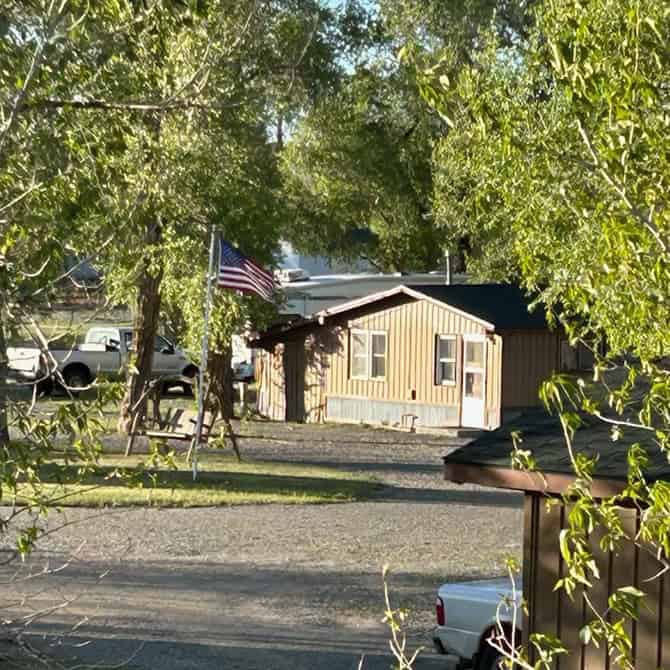 View of Oasis Motel with RV park and trees in Meeteetse, Wyoming.