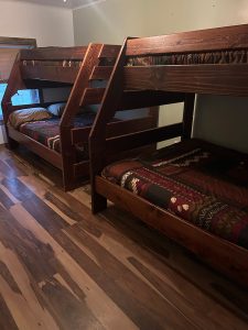 Wooden bunk beds with patterned bedding in a cozy motel room.